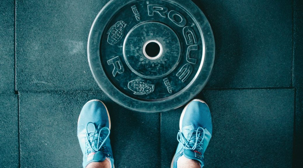 person standing beside black weights